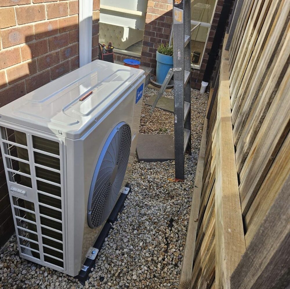 Midea outdoor unit beside brick home