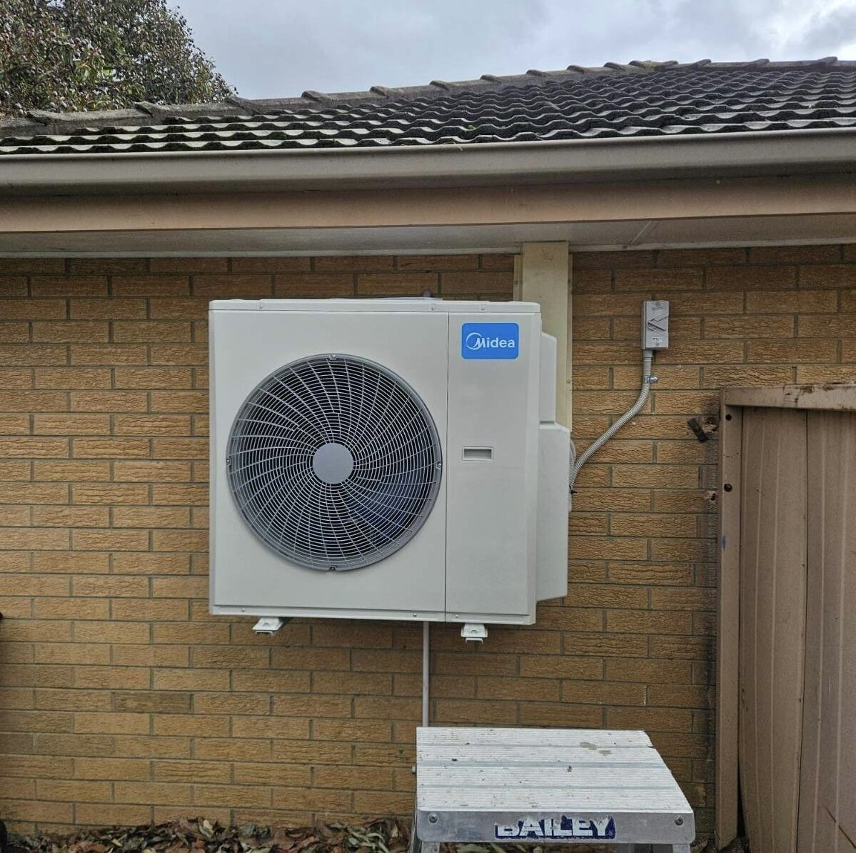 Midea outdoor on tile-roof brick home